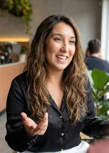 Flor Gonzalez sorrindo e gesticulando durante uma conversa